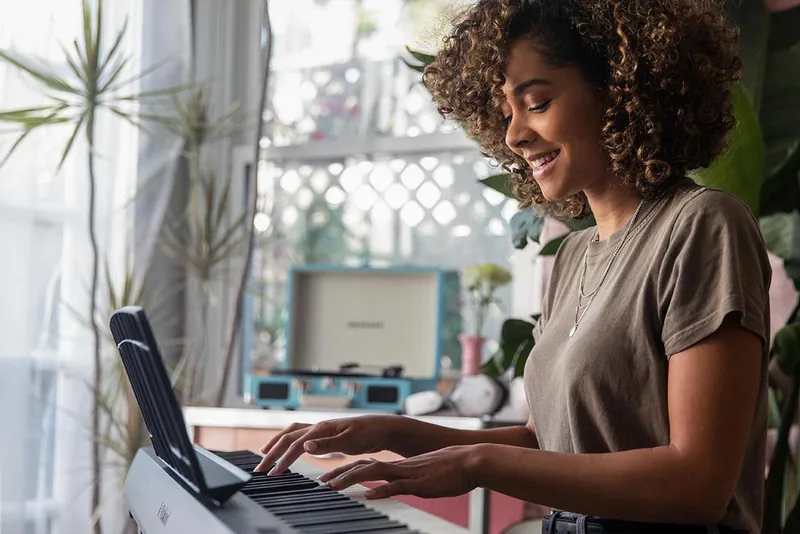 A beginner practising at a digital piano in a realistic home setting