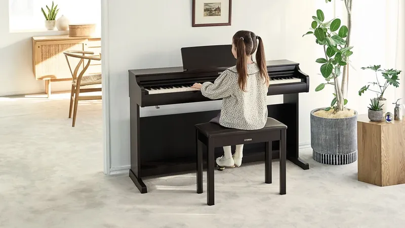 A girl playing a Yamaha YDP-166 console digital piano in a bright living room